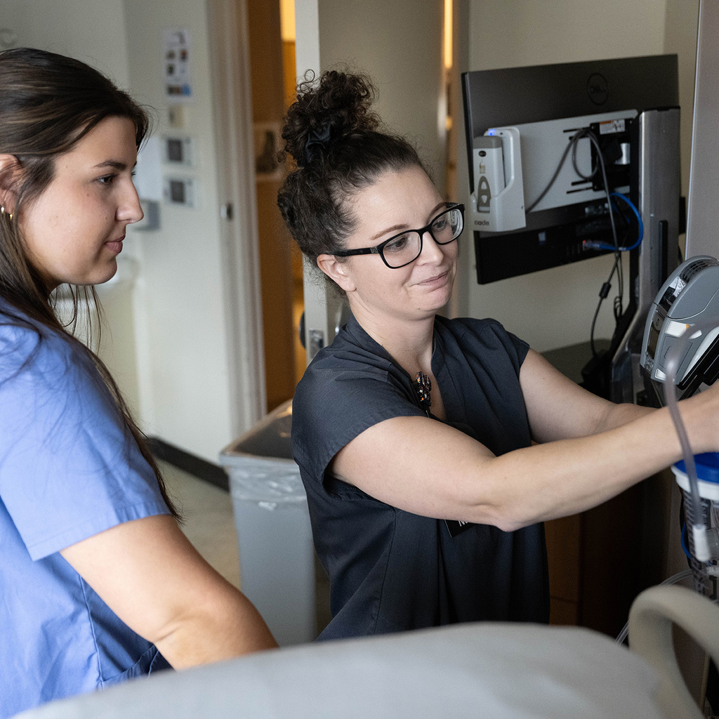 Nurse manager Jessica McDaniel offers instruction to Alana Gratton