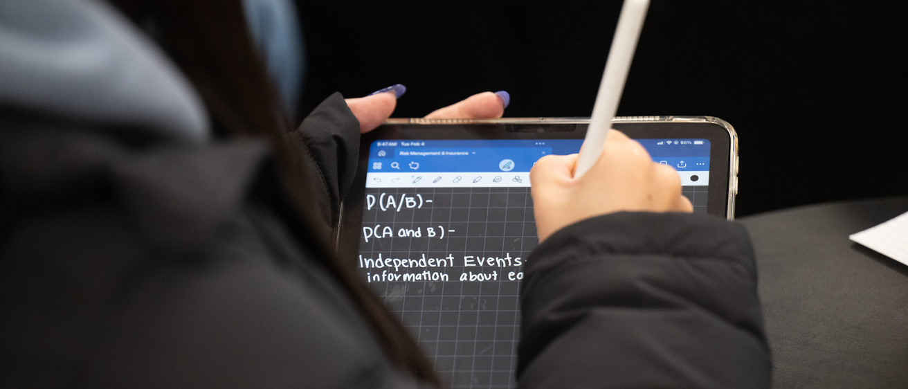 Student taking notes in a class