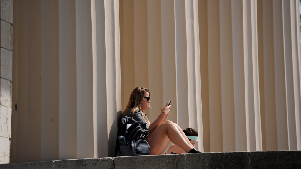 Student at Old Capital building looking at phone