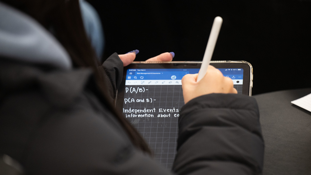 Student taking notes in a class